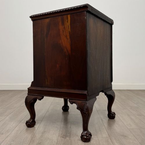 fig 4. A dark mahogany Chippendale style cupboard featuring a single door with an oval flame mahogany panel, carved borders, and cabriole legs with ball-and-claw feet.