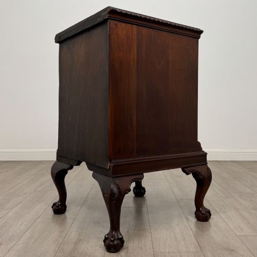 fig 6. A dark mahogany Chippendale style cupboard featuring a single door with an oval flame mahogany panel, carved borders, and cabriole legs with ball-and-claw feet.