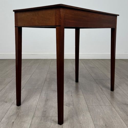 fig 3. An 18th-century Georgian mahogany writing table featuring a single drawer with brass handles and four square tapered legs.
