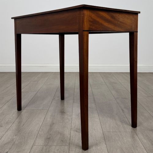 fig 5. An 18th-century Georgian mahogany writing table featuring a single drawer with brass handles and four square tapered legs.
