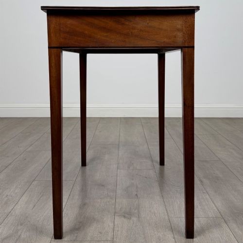 fig 6. An 18th-century Georgian mahogany writing table featuring a single drawer with brass handles and four square tapered legs.