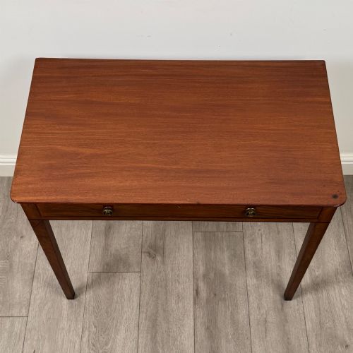 fig 8. An 18th-century Georgian mahogany writing table featuring a single drawer with brass handles and four square tapered legs.