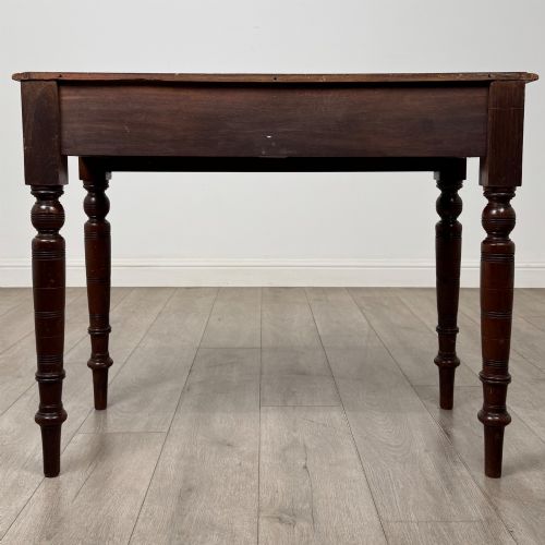 fig 4. A Victorian mahogany writing table featuring two frieze drawers with wooden knobs and turned reeded legs.