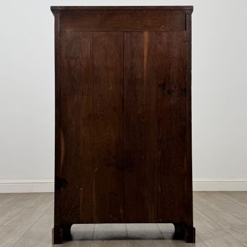 fig 5. An Edwardian open oak bookcase featuring three interior fixed shelves, dark timber finish, carved moulding on top uprights, and a shaped plinth base.