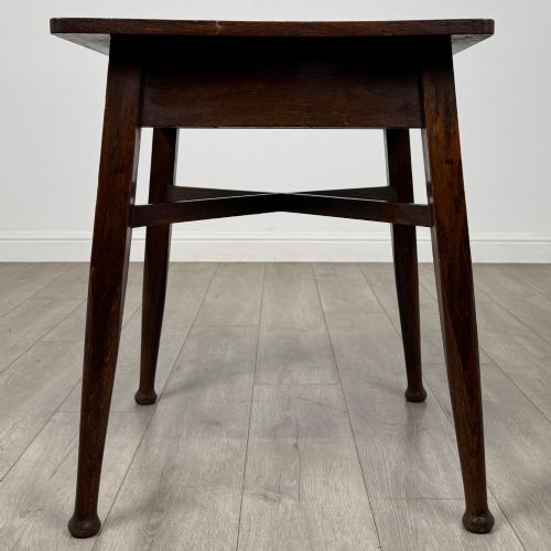 fig 2. An antique dark oak Edwardian side table featuring four tapered legs, an X-shaped lower stretcher, and a square top surface.