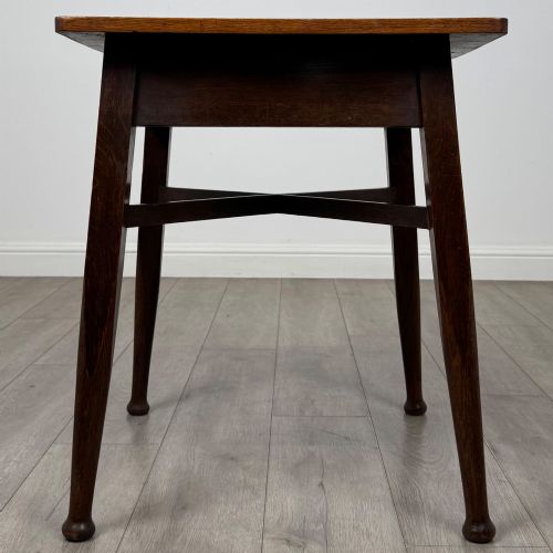fig 4. An antique dark oak Edwardian side table featuring four tapered legs, an X-shaped lower stretcher, and a square top surface.