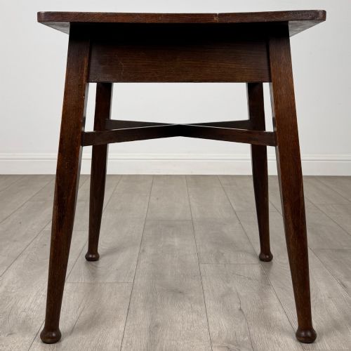 fig 6. An antique dark oak Edwardian side table featuring four tapered legs, an X-shaped lower stretcher, and a square top surface.