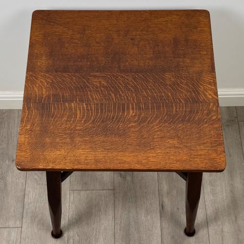 fig 8. An antique dark oak Edwardian side table featuring four tapered legs, an X-shaped lower stretcher, and a square top surface.