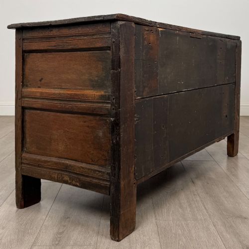 fig 4. A low dark oak Victorian cupboard featuring two doors with relief carvings of birds and flowers, flanked by leafy carved uprights and a carved frieze.