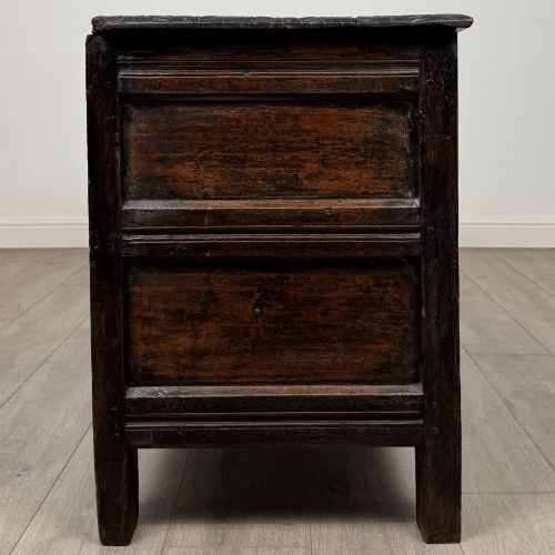fig 7. A low dark oak Victorian cupboard featuring two doors with relief carvings of birds and flowers, flanked by leafy carved uprights and a carved frieze.