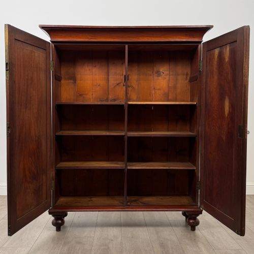 fig 1. An antique Victorian mahogany storage cabinet featuring two panelled doors, turned bun feet, and a classic moulded top cornicing.