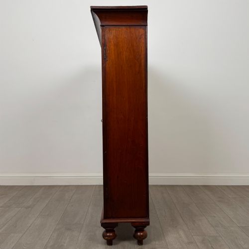 fig 3. An antique Victorian mahogany storage cabinet featuring two panelled doors, turned bun feet, and a classic moulded top cornicing.