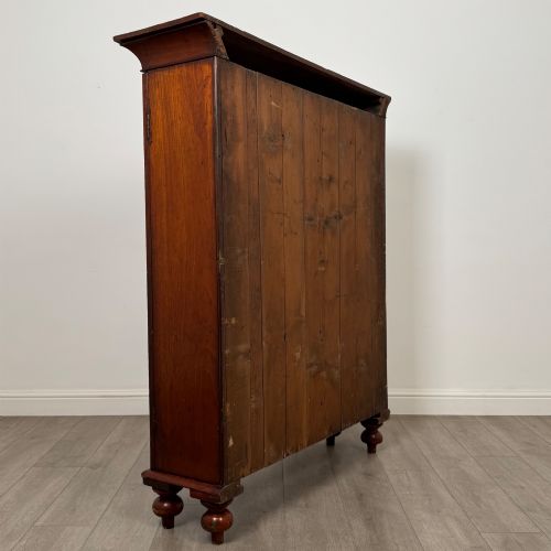 fig 4. An antique Victorian mahogany storage cabinet featuring two panelled doors, turned bun feet, and a classic moulded top cornicing.