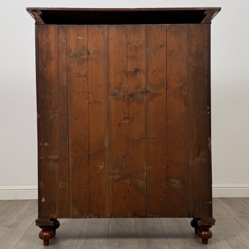 fig 5. An antique Victorian mahogany storage cabinet featuring two panelled doors, turned bun feet, and a classic moulded top cornicing.