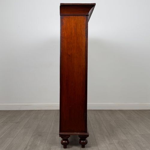 fig 7. An antique Victorian mahogany storage cabinet featuring two panelled doors, turned bun feet, and a classic moulded top cornicing.