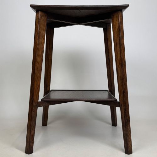 fig 2. An Edwardian dark oak side table featuring a square top, cross-stretchers, tapered legs, and a lower square shelf.