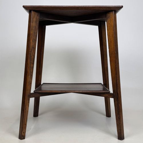 fig 4. An Edwardian dark oak side table featuring a square top, cross-stretchers, tapered legs, and a lower square shelf.