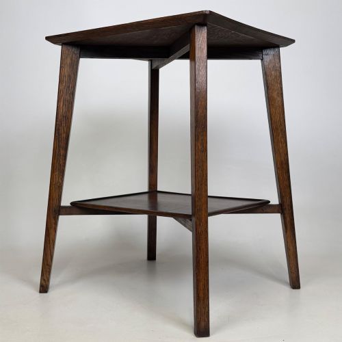fig 5. An Edwardian dark oak side table featuring a square top, cross-stretchers, tapered legs, and a lower square shelf.