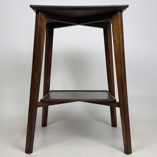 fig 6. An Edwardian dark oak side table featuring a square top, cross-stretchers, tapered legs, and a lower square shelf.