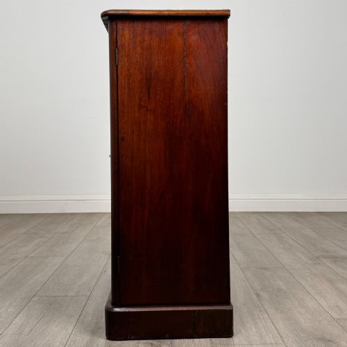 fig 3. A nineteenth-century mahogany display cabinet featuring twin glazed doors with arched framing and a plinth base.