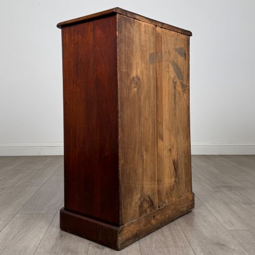 fig 4. A nineteenth-century mahogany display cabinet featuring twin glazed doors with arched framing and a plinth base.