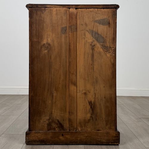fig 5. A nineteenth-century mahogany display cabinet featuring twin glazed doors with arched framing and a plinth base.