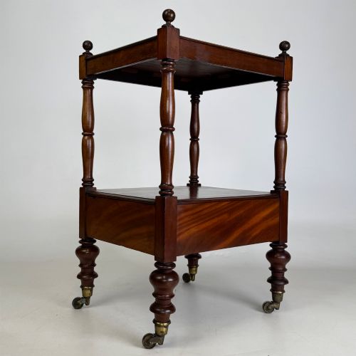 fig 3. A Victorian mahogany two-tiered stand featuring turned corner supports, top finials, a lower single drawer with a round wooden knob, and brass castors.