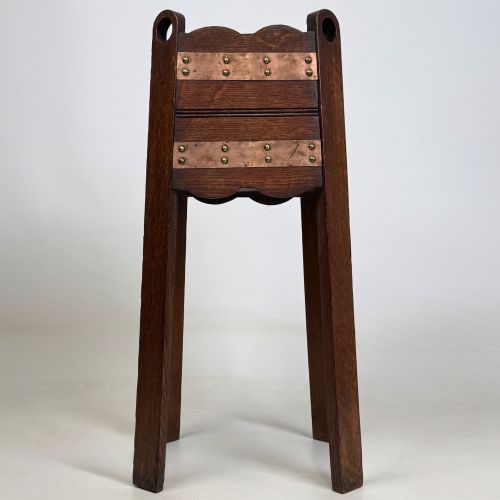 fig 2. An antique Arts and Crafts dark oak plant stand featuring copper straps with brass rivets, pierced handles, and scalloped edges.