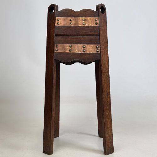 fig 4. An antique Arts and Crafts dark oak plant stand featuring copper straps with brass rivets, pierced handles, and scalloped edges.