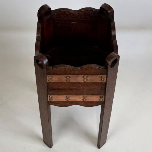 fig 8. An antique Arts and Crafts dark oak plant stand featuring copper straps with brass rivets, pierced handles, and scalloped edges.