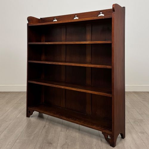 fig 2. An early 20th-century Arts and Crafts open walnut bookcase featuring four shelves and decorative pierced cut-outs on the top gallery and plinth base.