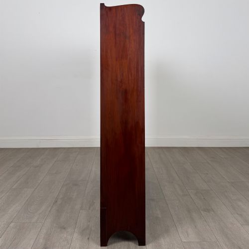 fig 7. An early 20th-century Arts and Crafts open walnut bookcase featuring four shelves and decorative pierced cut-outs on the top gallery and plinth base.