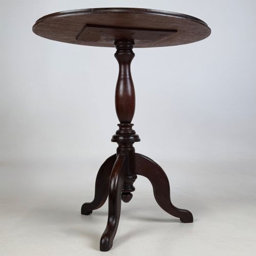 fig 1. An antique dark mahogany side table featuring a smooth oval top, a centrally turned pedestal stem, and three splayed tripod legs.