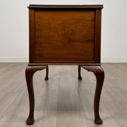 fig 2. A 20th-century walnut writing table featuring four drawers, decorative brass drop handles, an arched kneehole centre, and curved cabriole legs.