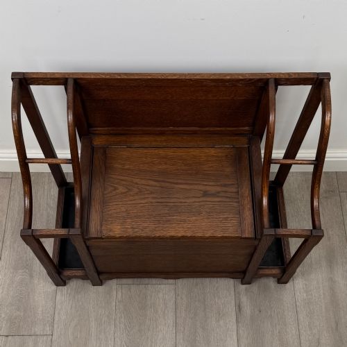 fig 8. An antique Edwardian golden oak hall seat featuring a central panelled backrest and integrated side umbrella stands with metal drip trays.