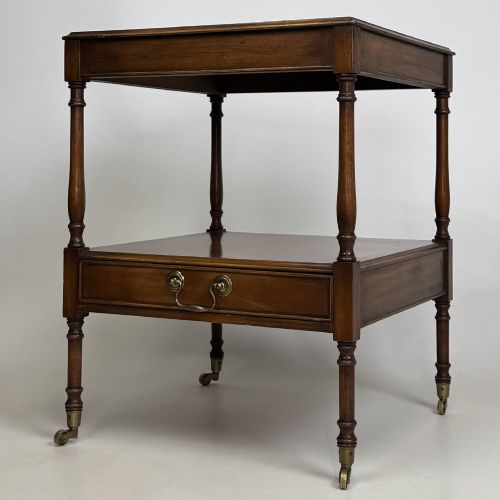 fig 2. A pair of 20th-century warm mahogany bedside tables featuring turned support pillars, open middle shelves, single lower drawers with brass handles, and brass castors.