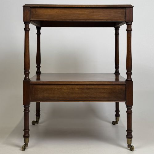fig 3. A pair of 20th-century warm mahogany bedside tables featuring turned support pillars, open middle shelves, single lower drawers with brass handles, and brass castors.