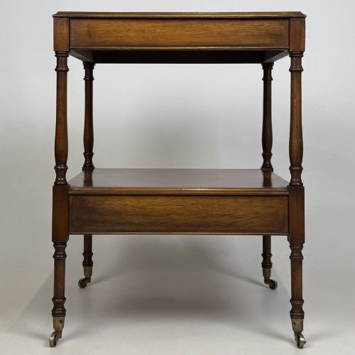 fig 7. A pair of 20th-century warm mahogany bedside tables featuring turned support pillars, open middle shelves, single lower drawers with brass handles, and brass castors.
