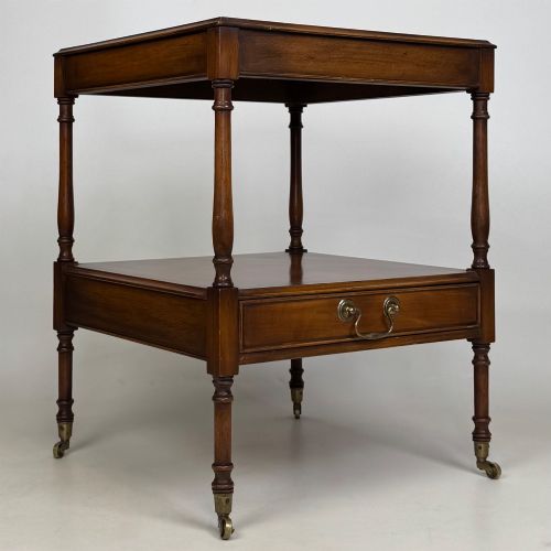 fig 8. A pair of 20th-century warm mahogany bedside tables featuring turned support pillars, open middle shelves, single lower drawers with brass handles, and brass castors.