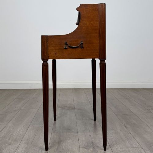 fig 2. A French mahogany side table featuring slim tapered fluted legs, a carved laurel motif apron, and a gallery back adorned with brass stars.