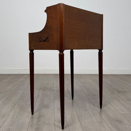 fig 3. A French mahogany side table featuring slim tapered fluted legs, a carved laurel motif apron, and a gallery back adorned with brass stars.