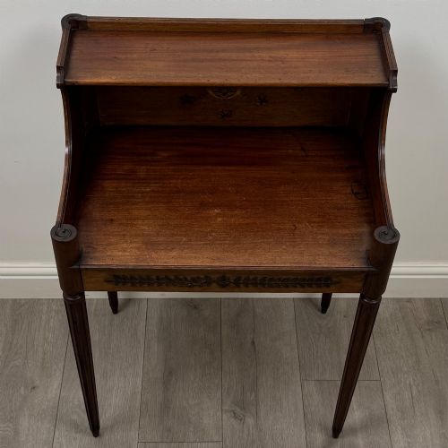 fig 8. A French mahogany side table featuring slim tapered fluted legs, a carved laurel motif apron, and a gallery back adorned with brass stars.