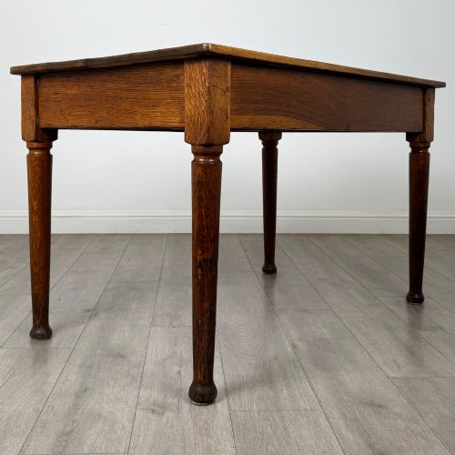 fig 3. An antique early 20th-century oak writing table featuring two front drawers with brass cup handles and turned legs.