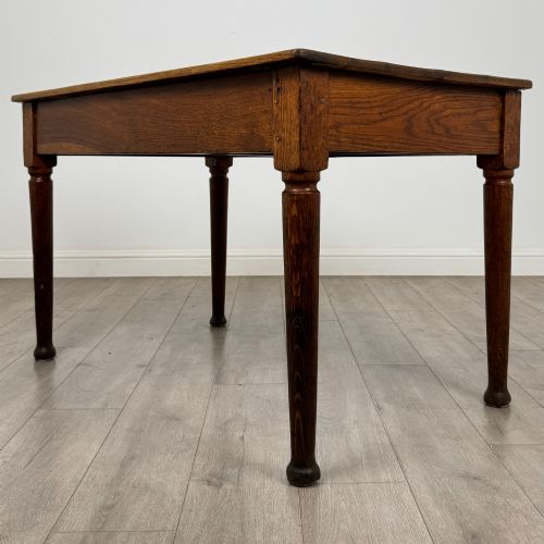 fig 5. An antique early 20th-century oak writing table featuring two front drawers with brass cup handles and turned legs.