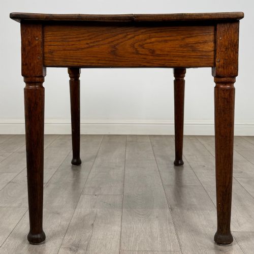 fig 6. An antique early 20th-century oak writing table featuring two front drawers with brass cup handles and turned legs.