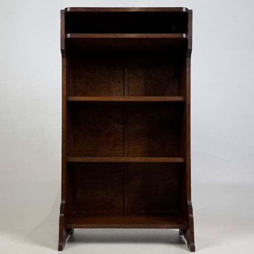 fig 1. A small Edwardian open bookcase crafted from dark oak timber featuring three open shelves and a shaped apron base.