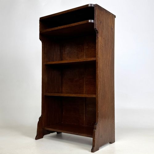 fig 2. A small Edwardian open bookcase crafted from dark oak timber featuring three open shelves and a shaped apron base.