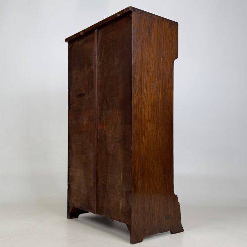 fig 6. A small Edwardian open bookcase crafted from dark oak timber featuring three open shelves and a shaped apron base.