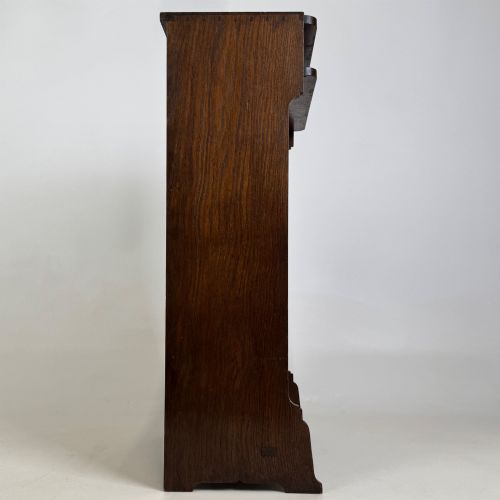 fig 7. A small Edwardian open bookcase crafted from dark oak timber featuring three open shelves and a shaped apron base.