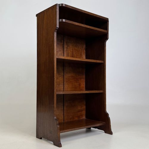 fig 8. A small Edwardian open bookcase crafted from dark oak timber featuring three open shelves and a shaped apron base.